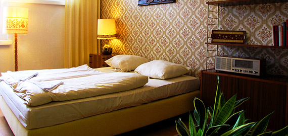 Chambre de l'hostel design RDA, chambre meublée d'objet, de papier peint et de meubles vintage